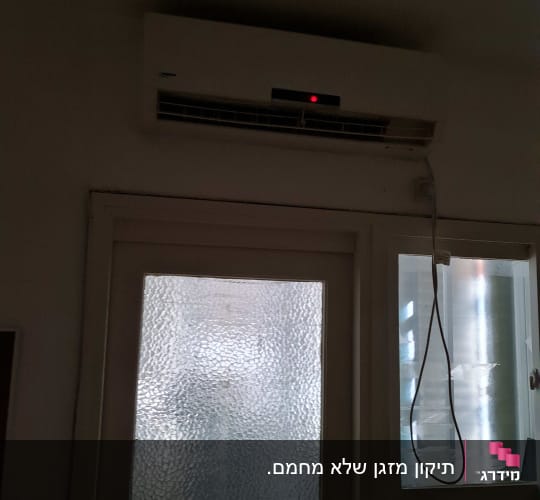 מזגן מותקן על קיר עם נורית אדומה דולקת